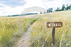 Trail sign on the grass field.