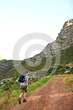 The trail starts here. a handsome young man enjoying a hike.