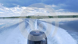 Trail on water surface behind of fast moving motor boat. the motor of motor boat, back view. Sea water ship trail with