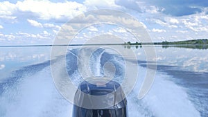 Trail on water surface behind of fast moving motor boat. the motor of motor boat, back view. Sea water ship trail with