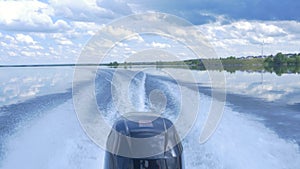 Trail on water surface behind of fast moving motor boat. the motor of motor boat, back view. Sea water ship trail with