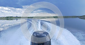 Trail on water surface behind of fast moving motor boat. the motor of motor boat, back view. Sea water ship trail with