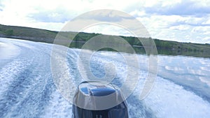 Trail on water surface behind of fast moving motor boat. the motor of motor boat, back view. Sea water ship trail with