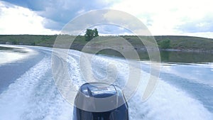 Trail on water surface behind of fast moving motor boat. the motor of motor boat, back view. Sea water ship trail with