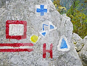 Trailblazing signs on a rock in Cernei Mountains.