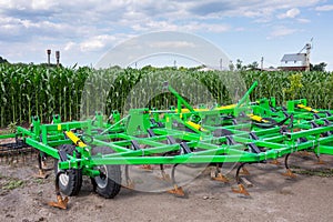 The trailed, five-row cultivator with combs and rollers stands on the material and technical base of the agricultural enterprise.