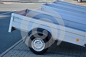 Trailer behind a car in the parking lot at the rental shop. just harness to the ball of the towing device. homologation and techni photo