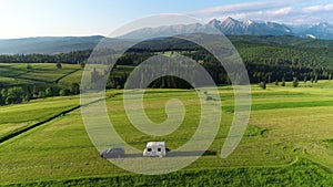 Trailer Caravaning in the mountains. Aerial view of RV car with trailer caravan, parked in the middle of mountain meadow