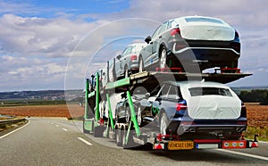 The trailer is engaged in the delivery of new cars