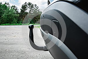 Trailer hitch or towbar on black car.