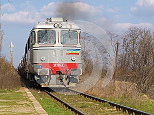 A train approaching and smoking, on the railway lines