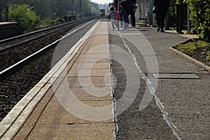 Train Approaching Station and People Waiting on Platform