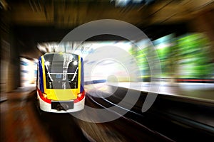 Train approaching station platform with blur motion