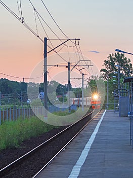 The train arrives at the village station platform in the evening