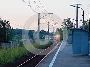 The train arrives at the village station platform in the evening