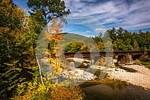 Train bridge over a river and autumn color near Bethel, Maine. photo