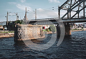 A train bridge over a river in the city