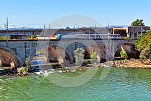 Train on the bridge over the river in Piedmont, Italy.