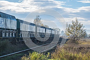 Train carrying coal or sand. Wagons on the railway