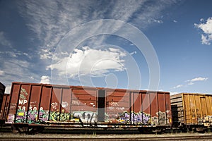 Train Cars with Graffiti Against a Blue Sky