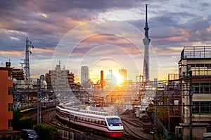 Train in city in Tokyo with sunset background