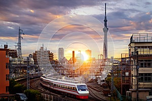 Train in city in Tokyo with sunset background photo