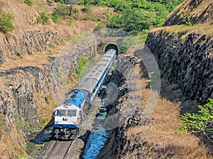 Train coming out of a tunnel in Konkan region of Maharashtra, India.