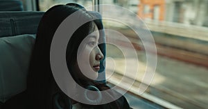 Train, commute and woman with headphones on journey, transportation or travel in Japan. City, metro and girl at window