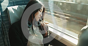 Train, commute and woman on journey sleeping on transportation in Japan with headphones. Tired, fatigue and girl travel