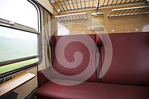 Train compartment with red seats with the view