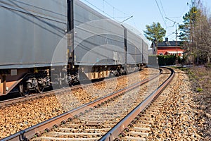 Train in a curve with a red house in the direction of the railway track