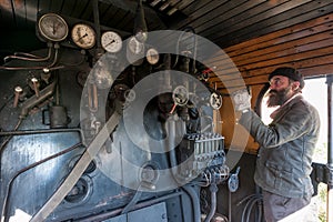 The train driver near the steam locomotive boiler