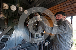The train driver near the steam locomotive boiler