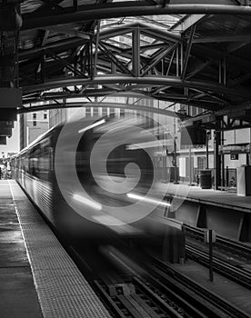 Train on elevated tracks within buildings at the Loop, Chicago City Center - Black and White with Long Exposure Artistic Effect -