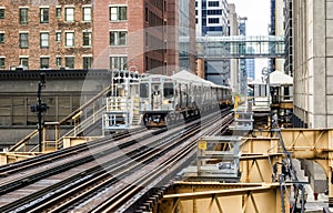 Train on elevated tracks within buildings at the Loop, Glass and Steel bridge between buildings - Chicago City Center - Chicago, I