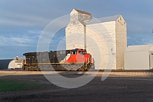 Train engine parked in front of old grain elevators