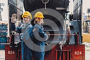 Train engineer team working service maintenance old dirty vintage classic steam engine locomotive in train repair workshop at