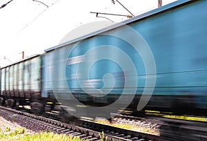 Train with freight wagons in motion on electrified railway