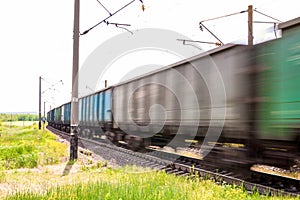 Train with freight wagons in motion on electrified railway