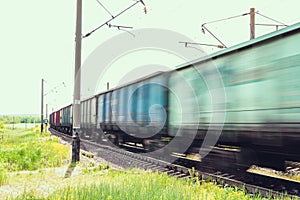 Train with freight wagons in motion on electrified railway