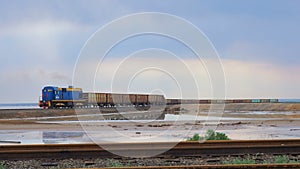 Train with freight wagons trailed carries cargo. The locomotive carries salt salty lake Baskunchak.