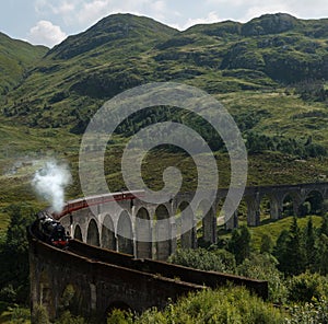 A train at Glenfinnan Viaduct famous from Harry Potter movies in Scotland