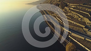 Train Goes Along Lake Geneva Shore at Sunset. Vineyards of Lavaux. Aerial View