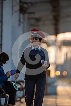 A train guard walking on the platform
