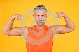 Train hard be strong. Strong man flex arms yellow background. Building strong biceps and triceps. Happy athlete show