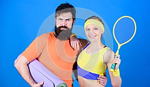 Train hard, win easy. Happy woman and bearded man workout in gym. Sporty couple training with fitness mat and tennis