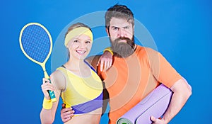 Train hard, win easy. Happy woman and bearded man workout in gym. Sporty couple training with fitness mat and tennis