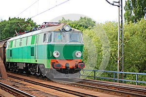 Train hauled by electric locomotive on a sunny day in Poznan, Poland