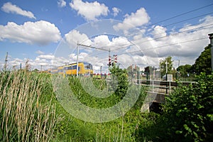 Train heading towards a level crossing on a sunny day