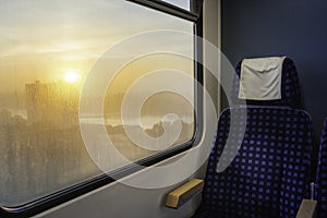 Train interior with chair and sunrise view on window. Train travel